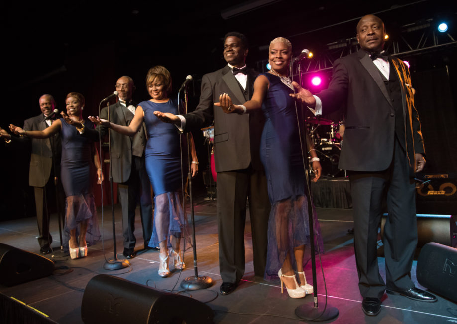 The Fabulous Motown Revue lined up on stage looking at a crowd.